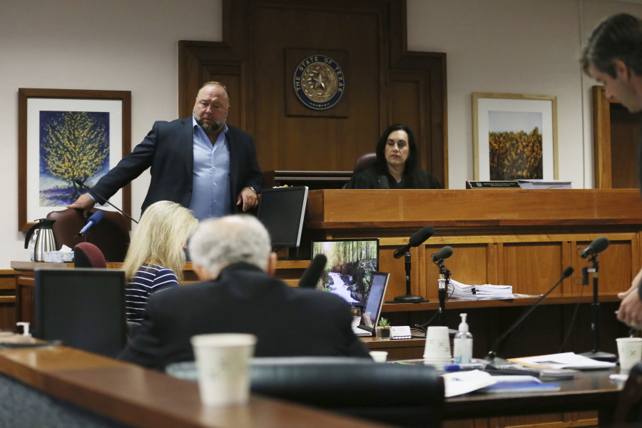 Alex Jones takes a seat to testify in court at t the Travis County Courthouse, Wednesday Aug. 3, 2022, in Austin, Texas.