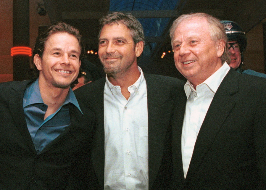 FILE - Actors Mark Wahlberg, left, and George Clooney, center, stars of the film "The Perfect Storm,'' pose with director/producer Wolfgang Petersen at the premiere in Danvers, Mass., on  June 28, 2000. Petersen, the German filmmaker whose WWII submarine epic ,??Das Boot,?? propelled him into a blockbuster Hollywood career, died Friday at his home in the Los Angeles neighborhood of Brentwood after a battle with pancreatic cancer.