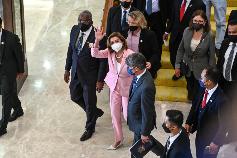 This handout photo taken and released by Malaysia's Department of Information, U.S. House Speaker Nancy Pelosi, center, waves to media as she tours the parliament house in Kuala Lumpur, Tuesday, Aug. 2, 2022. Pelosi arrived in Malaysia on Tuesday for the second leg of an Asian tour that has been clouded by an expected stop in Taiwan, which would escalate tensions with Beijing.