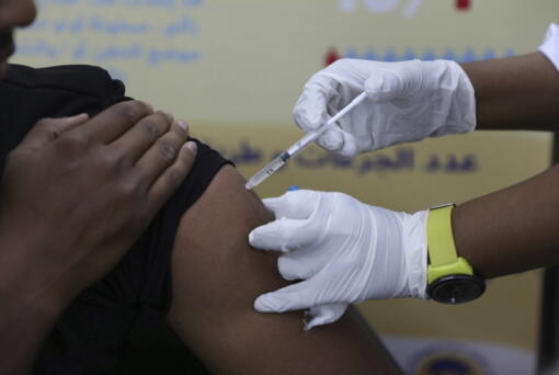 FILE - A man receives the AstraZeneca COVID-19 vaccine at Jabra Hospital in Khartoum, Sudan, Thursday, March 11, 2021.  A new philanthropic project hopes to invest $100 million in up to 10 countries mostly in Africa by 2030 to support up to 200,000 community health workers.