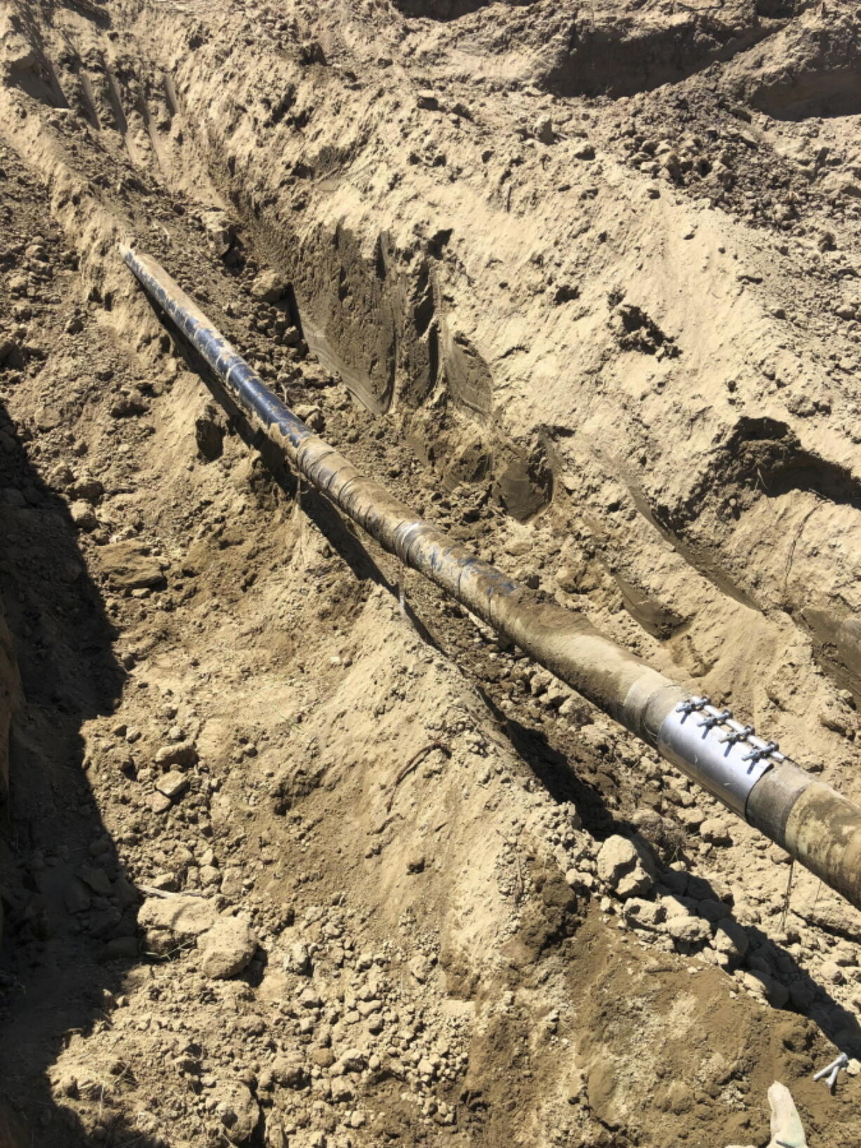 This undated photo provided by Bridge Pipeline shows repairs made to a six-inch pipeline transporting diesel that broke and spilled more than 45,000 gallons of fuel on July 27, 2022. near Sussex, Wyo. The line is owned by a Wyoming company that's being sued by federal prosecutors over previous spills in two other states.