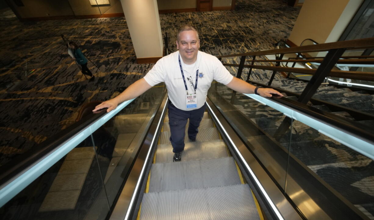 Student resource officer Tony Ramaeker, from Elkhorn, Neb., heads up an escalator while attending a convention  July 5 in Denver.