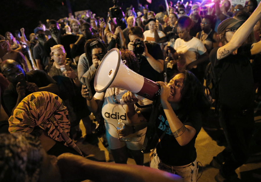 FILE -  LaShell Eikerenkoetter chants, on a megaphone protesting the recent acquittal of a white former police officer, Jason Stockley, in the killing of a black man, Anthony Lamar Smith, on Friday, Sept. 22, 2017 in St. Charles, Mo.  On Aug. 3, Mayor Tishaura Jones signed into law an ordinance establishing a Division of Civilian Oversight. But three police officer associations are suing to stop the measure that they claim hinders due process for officers and conflicts with state law. (David Carson/St.