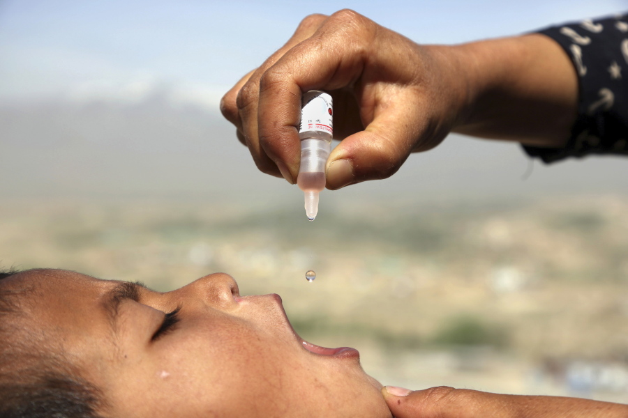 FILE - An Afghan health worker uses an oral polio vaccine on a child as part of a campaign to eliminate polio, on the outskirts of Kabul, Afghanistan, April 18, 2017. For years, global health officials have used billions of drops of an oral vaccine in a remarkably effective campaign aimed at wiping out polio in its last remaining strongholds -- typically, poor, politically unstable corners of the world. Now, in a surprising twist in the decades-long effort to eradicate the virus, authorities in Jerusalem, New York and London have discovered evidence that polio is spreading there. The source of the virus? The oral vaccine itself.