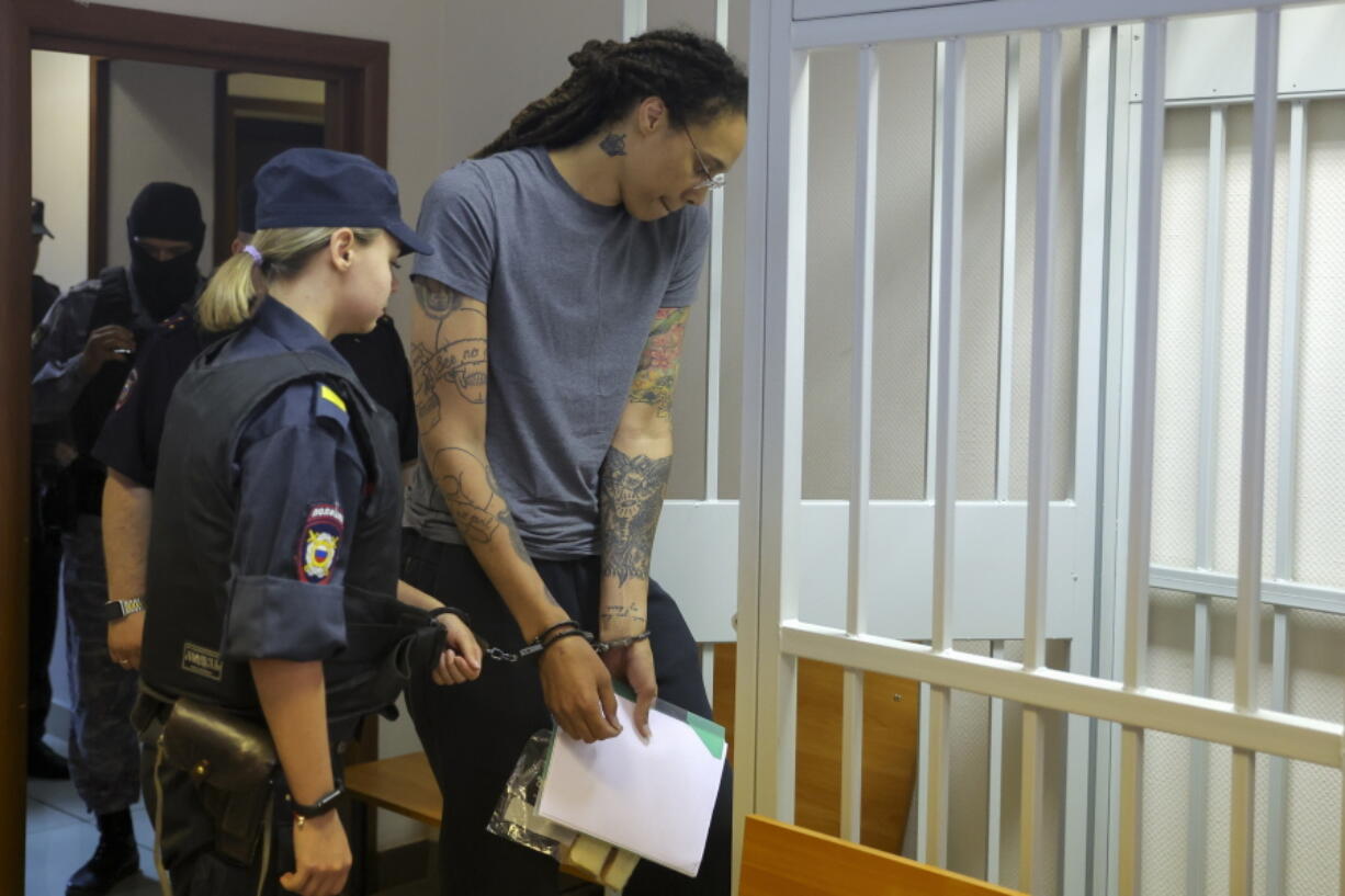 WNBA star and two-time Olympic gold medalist Brittney Griner, right, enters a cage in a courtroom prior to a hearing in Khimki just outside Moscow, Russia, Thursday, Aug. 4, 2022. Closing arguments in Brittney Griner's cannabis possession case are set for Thursday, nearly six months after the American basketball star was arrested at a Moscow airport in a case that reached the highest levels of US-Russia diplomacy.