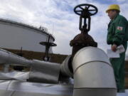 FILE - Istvan Szekeres, engineer of the Hungarian Oil and Gas Company (MOL) checks the receiving area of the Druzhba oil pipeline in the country's largest oil refinery in Szazhalombata, south of Budapest, Hungary, Jan. 9, 2007. Several countries in Europe dependent on Russian energy suffered another blow with confirmation Tuesday, Aug. 9, 2022 that oil shipments have stopped through a critical pipeline. Russian state pipeline operator Transneft said it halted shipments through the southern branch of the Druzhba oil pipeline, which flows through Ukraine to the Czech Republic, Slovakia and Hungary.