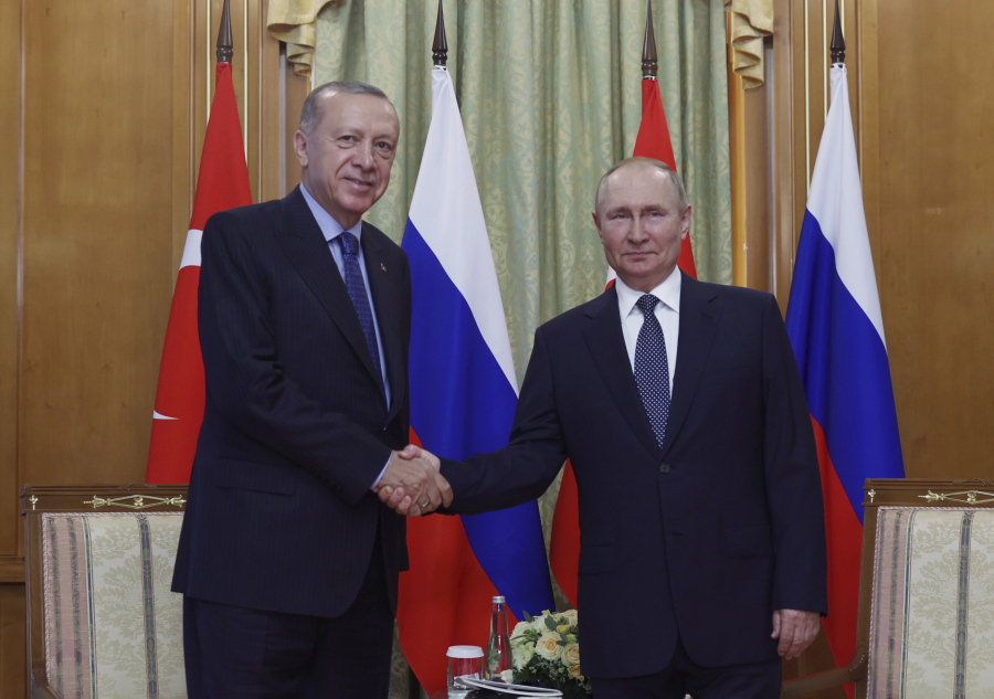 In this handout photo provided by the Turkish Presidency, Turkish President Recep Tayyip Erdogan, left, and Russian President Vladimir Putin shake hands prior to their meeting at the Rus sanatorium in the Black Sea resort of Sochi, Russia, Friday, Aug.
