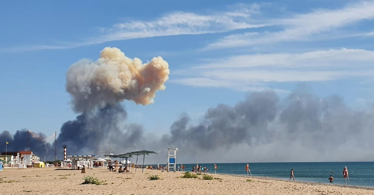 Rising smoke can be seen from the beach at Saky after explosions were heard from the direction of a Russian military airbase near Novofedorivka, Crimea, Tuesday Aug. 9, 2022. The explosion of munitions caused a fire at a military air base in Russian-annexed Crimea Tuesday but no casualties or damage to stationed warplanes, Russia's Defense Ministry said.