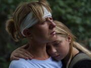 Nelia Fedorova, left, is embraced by her daughter, Yelyzaveta Gavenko, 11, as they visit a neighbor's home where someone was killed in a Russian rocket attack Friday night which also injured Federova, in Kramatorsk, Donetsk region, eastern Ukraine, Saturday, Aug. 13, 2022. The strike killed three people and wounded 13 others, according to the mayor.