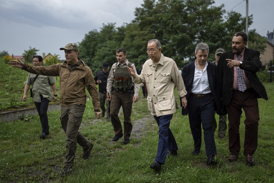 Former U.N. Secretary-General Ban Ki-moon, centre, and former Colombia's President Juan Manuel Santos, centre right, walk during their visit in Bucha near Kyiv, Ukraine, Tuesday, Aug. 16, 2022. The former leader of the United Nations called on the world Tuesday to honour civilian victims killed during the Russian attack on Kyiv.