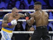 Britain's Anthony Joshua, right, takes a blow from Ukraine's Oleksandr Usyk during their world heavyweight title fight at King Abdullah Sports City in Jeddah, Saudi Arabia, Sunday, Aug. 21, 2022.