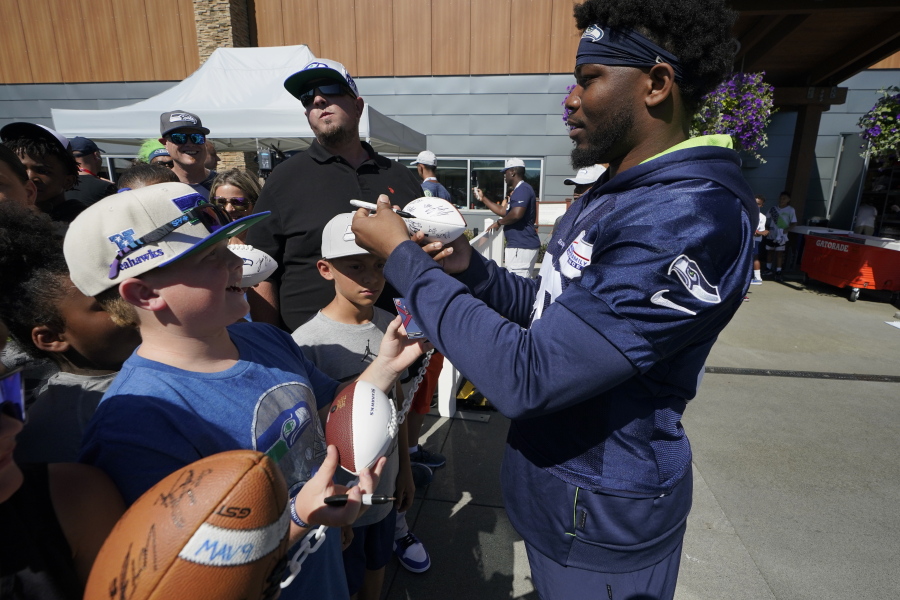 Seattle Seahawks running back Rashaad Penny signs autographs for fans after NFL football practice Wednesday, Aug. 3, 2022, in Renton, Wash. (AP Photo/Ted S.