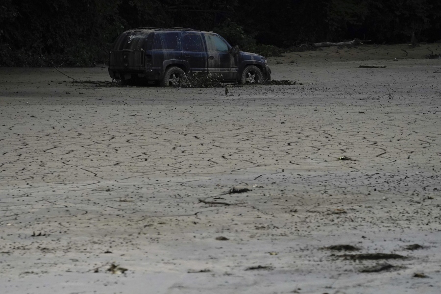 A vehicle is abandoned and surrounded by mud caused by massive flooding on Friday, Aug. 5, 2022, near Haddix, Ky.