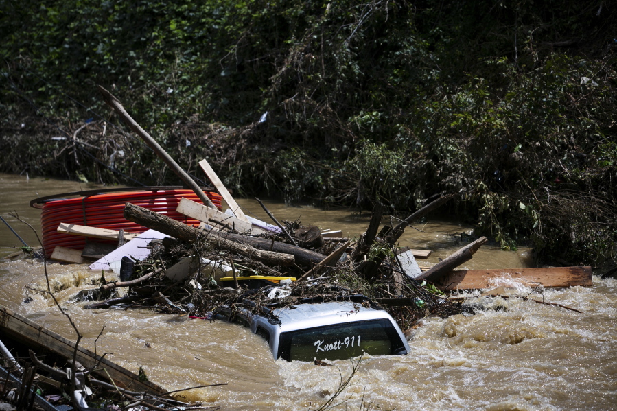 A truck is washed away by floodwaters in the Troublesome Creek near Main Street, in Hindman, Ky., Monday, Aug. 1, 2022. The creek has started to recede, leaving business owners in the town to start cleanup efforts.
