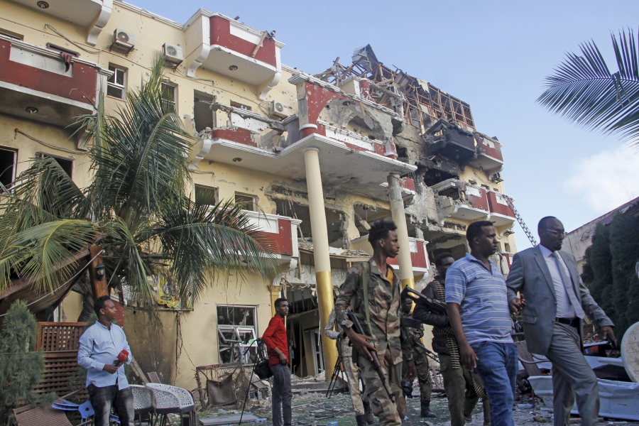 Security forces and others walk in front of the damaged Hayat Hotel in the capital Mogadishu, Somalia Sunday, Aug. 21, 2022. Somali authorities on Sunday ended a deadly attack in which at least 20 people were killed and many others wounded when gunmen from the Islamic extremist group al-Shabab, which has ties with al-Qaida, stormed the Hayat Hotel in the capital on Friday evening.