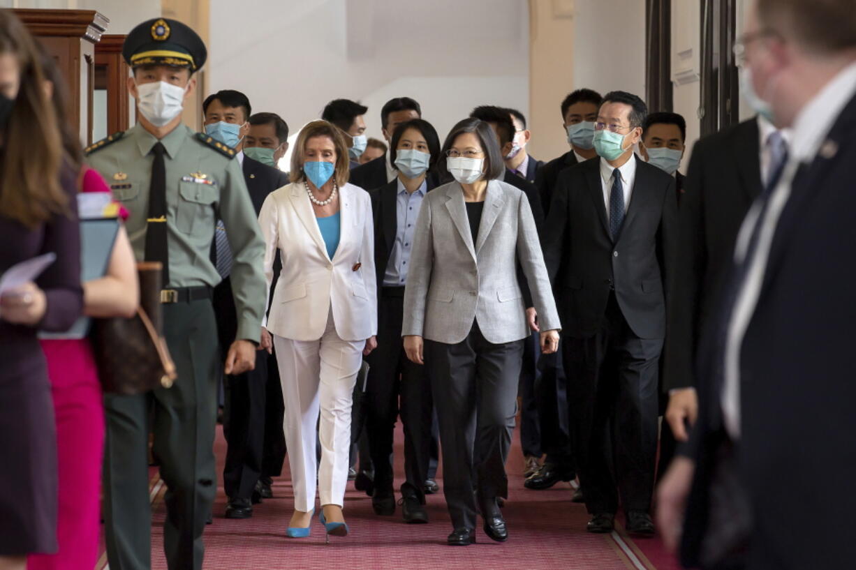 In this photo released by the Taiwan Presidential Office, U.S. House Speaker Nancy Pelosi, center left, and Taiwanese President President Tsai Ing-wen arrive for a meeting in Taipei, Taiwan, Wednesday, Aug. 3, 2022. U.S. House Speaker Nancy Pelosi, meeting top officials in Taiwan despite warnings from China, said Wednesday that she and other congressional leaders in a visiting delegation are showing they will not abandon their commitment to the self-governing island.