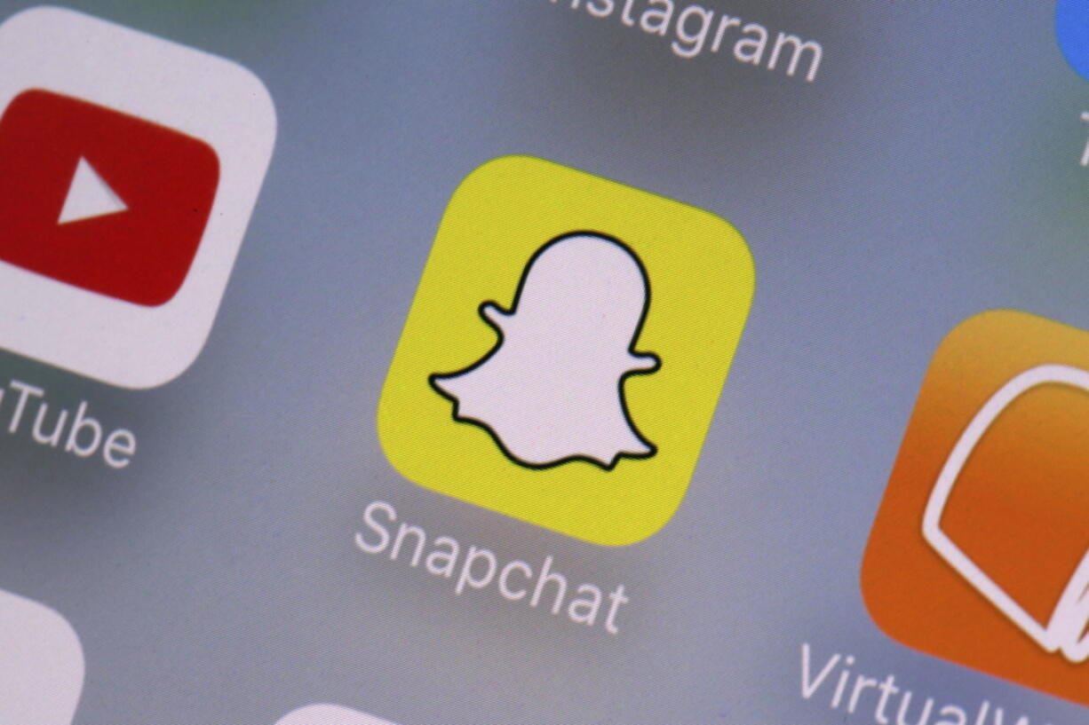 FILE - The Snapchat app is seen on a mobile device in New York, Aug. 9, 2017. As concerns about social media's impact on teen psychology continue to rise, platforms from Snapchat to TikTok to Instagram are bolting on new features they say will make their services safer and more age appropriate.