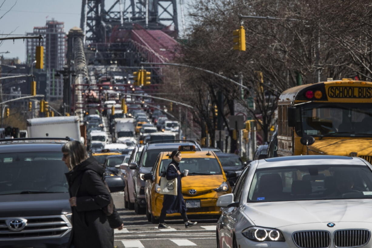 FILE - Pedestrians cross Delancey Street as congested traffic from Brooklyn enters Manhattan over the Williamsburg Bridge, March 28, 2019, in New York. Roadway deaths rose 7% during the first three months of 2022 to 9,560 people, the highest number for a first quarter in two decades, according to estimates by the National Highway Traffic Safety Administration.