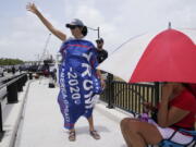 A Donald Trump supporter stands on a bridge outside the entrance to former President Donald Trump's Mar-a-Lago estate, Tuesday, Aug. 9, 2022, in Palm Beach, Fla. The FBI searched Trump's Mar-a-Lago estate as part of an investigation into whether he took classified records from the White House to his Florida residence, people familiar with the matter said Monday.