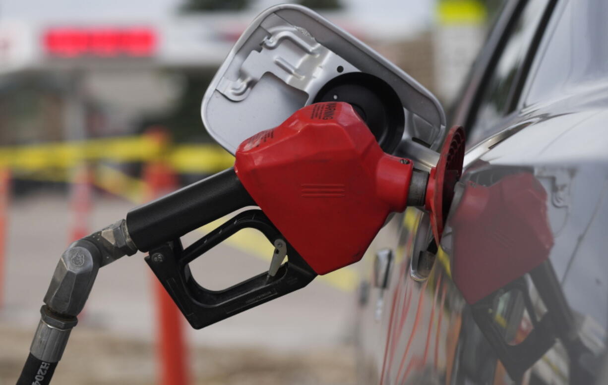 FILE - A motorist fills up the tank on a sedan, on July 22, 2022, in Saratoga, Wyo. Gasoline prices are sliding back toward the $4 mark for the first time in more than five months -- good news for consumers who are struggling with high prices for many other essentials.
