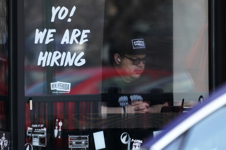 FILE - A hiring sign is displayed at a restaurant in Schaumburg, Ill., Friday, April 1, 2022.  More Americans applied for jobless benefits last week, reported Thursday, Aug. 4, 2022,  as the number of unemployed continues to rise modestly, though the labor market remains one of the strongest parts of the U.S. economy.   (AP Photo/Nam Y.