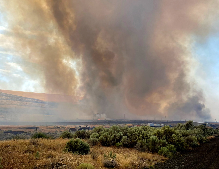 This photo provided by the Washington State Department of Transportation shows smoke from a wildfire burning south of Lind, Wash. on Thursday, Aug. 4, 2022. Sheriff's officials are telling residents in the town of Lind in eastern Washington to evacuate because of a growing wildfire south of town that was burning homes.