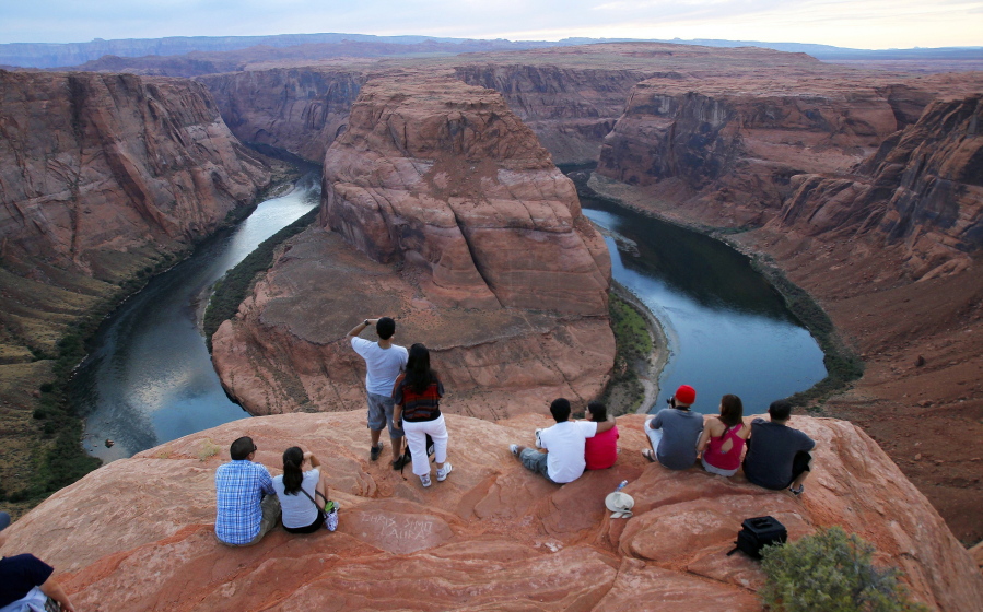 FILE - Visitors view the dramatic bend in the Colorado River at the popular Horseshoe Bend in Glen Canyon National Recreation Area, in Page, Ariz., on Sept. 9, 2011. Federal officials on Tuesday, Aug. 16, 2022, are expected to announce water cuts that would further reduce how much Colorado River water some users in the seven U.S. states reliant on the river and Mexico receive. (AP Photo/Ross D.