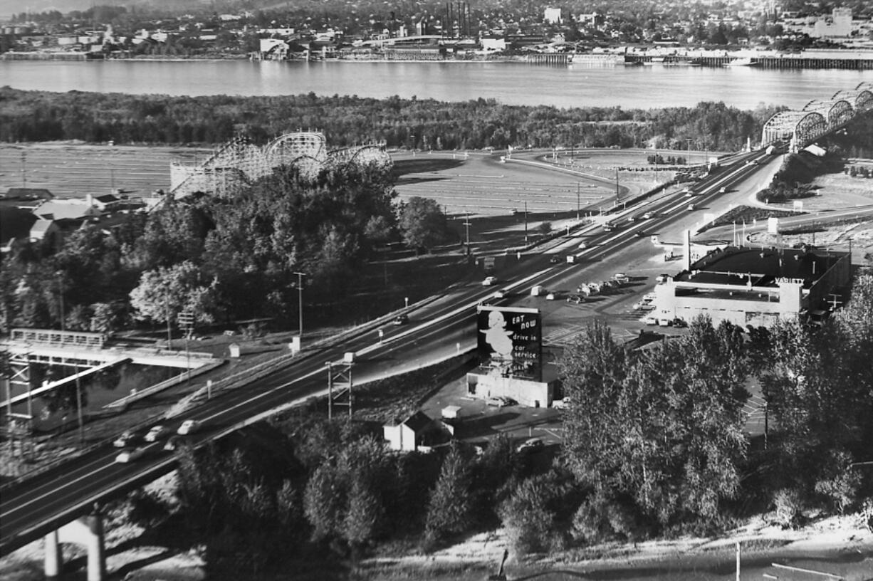 This 1953 photograph shows Jantzen Beach Amusement Park, along with its swimming pool and roller coaster, as well as the single-spanned Interstate 5 Bridge across the Columbia River.