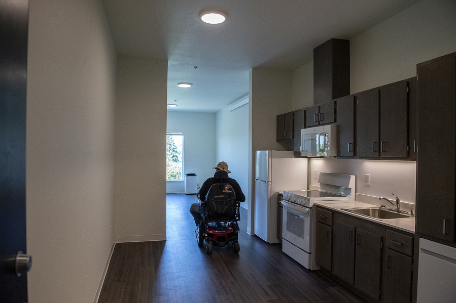 Future resident Deone Washington tours a one-bedroom unit during the grand opening ceremony in July for Miles Terrace, a new 69-unit affordable housing complex for low-income seniors in downtown Vancouver.