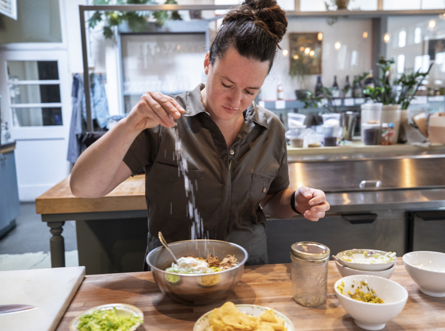 Chef Liz Kenyon from Manolin in Fremont prepares her version of their ultimate tuna salad sandwich, adding salt before stirring everything together on Wednesday, July 7, 2021.