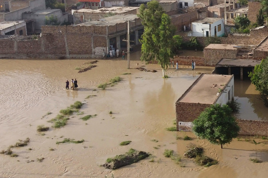 Residents wade through a flood hit area following heavy monsoon rains in Charsadda district of Khyber Pakhtunkhwa on Aug. 29, 2022. The death toll from monsoon flooding in Pakistan since June has topped more than 1,000, according to figures released on Aug. 29, 2022, by the country's National Disaster Management Authority.