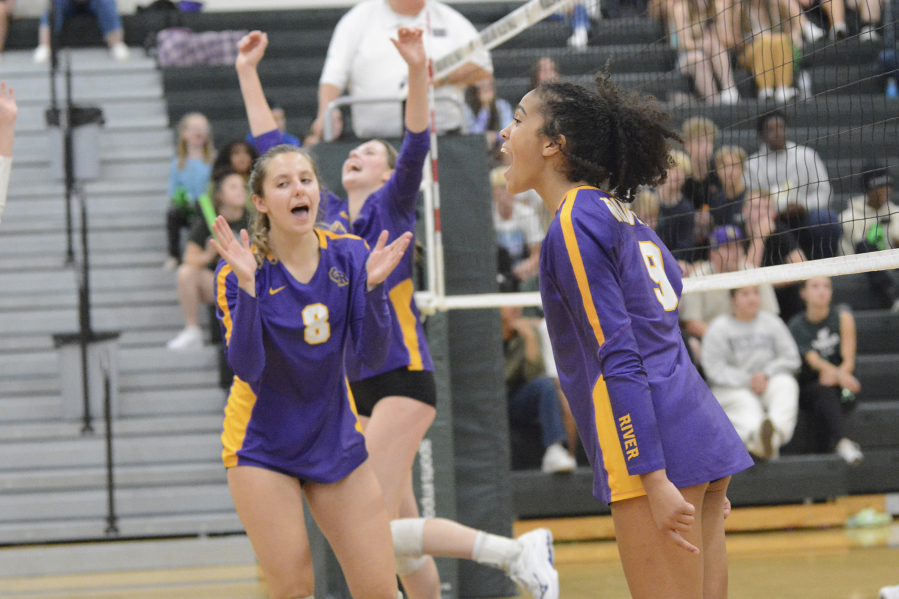 Columbia River's Macey McCoy (9) and Taegen Benke (8) celebrate match point in the Rapids' season-opening win over Woodland on Tuesday at Woodland High School.