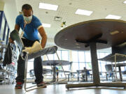 Lester Harris cleans chairs and tables as part of his job at the Rite Aid Distribution Center in Aberdeen.