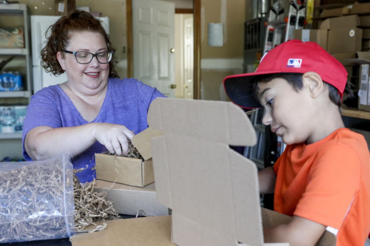 Jenny Piper, left, with her son Jose Piper, 7, assembles disaster preparedness kits at their home in Bothell, Washington on August 11, 2022.