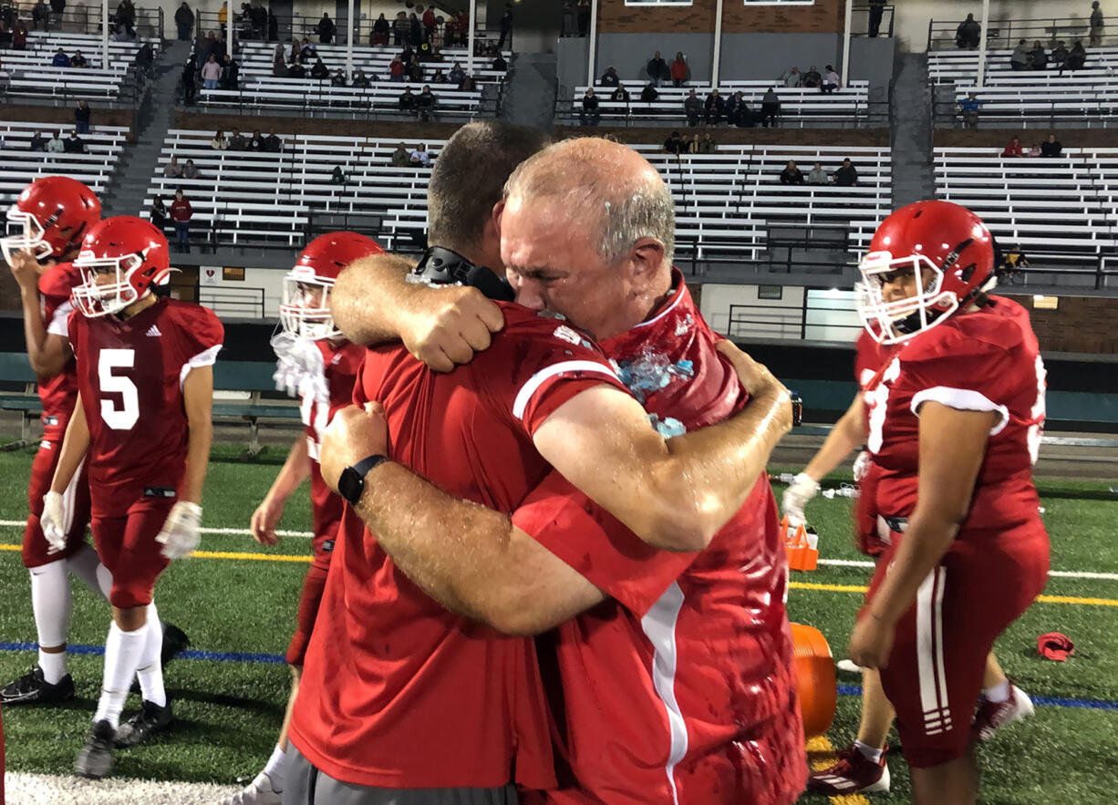 Fort Vancouver coach Doug Bilodeau hugs an assistant coach after a 29-27 win over Stevenson on Friday.