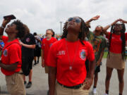 Red Tail Cadets, from left in red shirts, Jalen Reynolds, Tyrese Walker, Anyah Brown and Micah Riggs, watch aircraft fly overhead on Sunday, June 12, at June's Spirit of St. Louis Air Show in Chesterfield, Missouri. The cadets were presented to air show goers.
