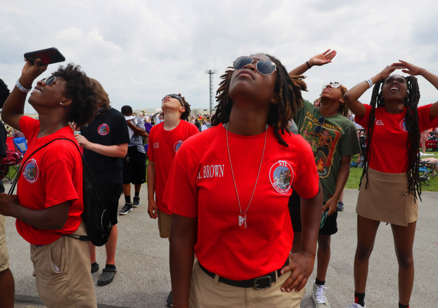Red Tail Cadets, from left in red shirts, Jalen Reynolds, Tyrese Walker, Anyah Brown and Micah Riggs, watch aircraft fly overhead on Sunday, June 12, at June's Spirit of St. Louis Air Show in Chesterfield, Missouri. The cadets were presented to air show goers.