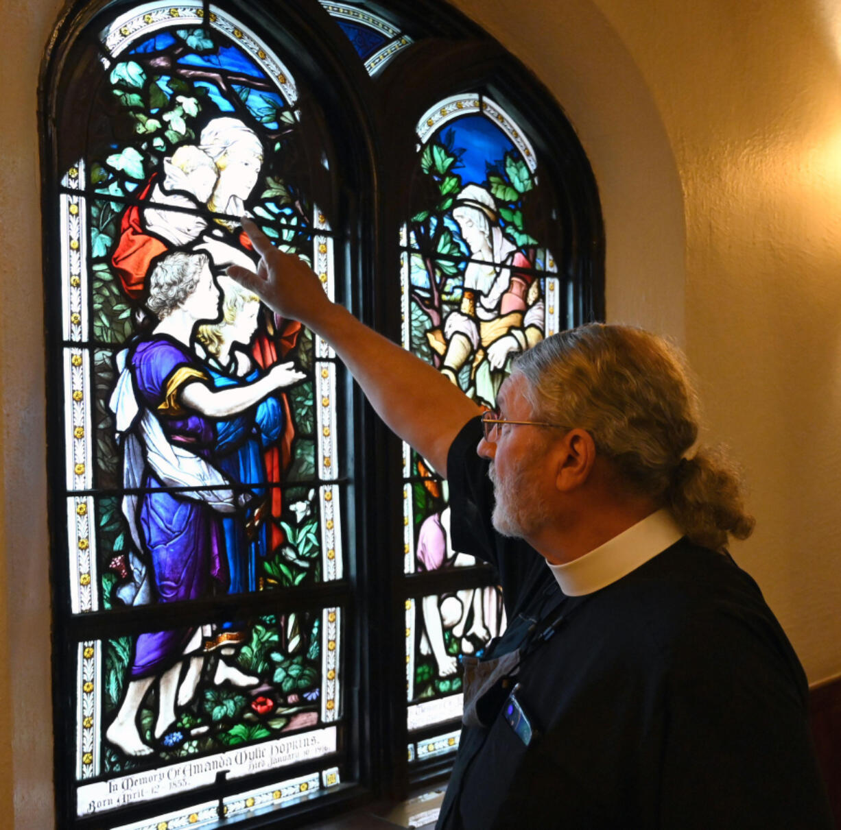 The Rev. Canon Dr. Mark Gatza, rector for Emmanuel Episcopal Church, talks about details in the glass as he explains the stories depicted in them during a tour of the church on Sept.