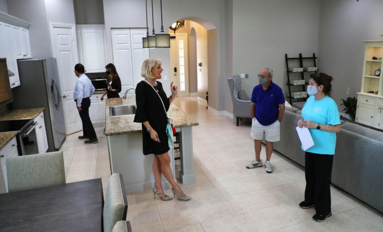 Realtor Maria Montalbano, middle, talks to potential buyers during an open house in Parkland on May 25, 2021.