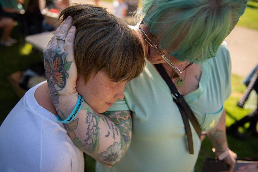 Anna Saiz and her son Dolan Saiz, 11, share a moment at the Hands Across the Bridge event while honoring Jon "JT" Saiz, husband and father, who died last year of COVID-19.
