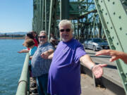 Hands Across the Bridge event emcee Steve Mahoney, in purple, joins hands with other folks in recovery from addiction. Mahoney said he's celebrating 19 years of being clean and sober.