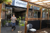 Angie Miller, manager of Elements, prepares to sweep out the restaurant's parklet.