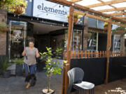 Angie Miller, manager of Elements, prepares to sweep out the restaurant's parklet.