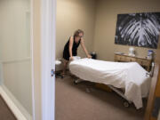 Massage therapist Jessica Sanchez-Harper prepares a therapy room for the next client at WellSpace in southeast Vancouver. "This really is invented," said Vince Williams, the company's co-owner and CEO. WellSpace uses a gymlike membership model to provide rentable treatment rooms for massage therapists.