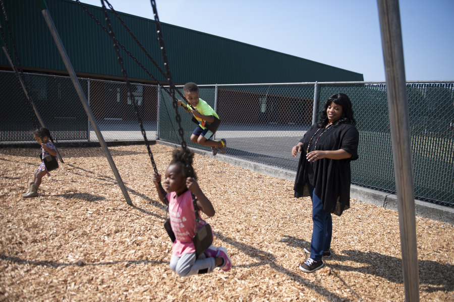 Preschool students Akina Monnette, from left, Christian Conley, in green, and Nevaeh Bender, in pink, catch a ride on the swings while getting a helpful push from supervising teacher Tamara Harris at Evergreen High School on Friday morning. A lack of federal funding has put an even larger dent in the capacity of local Head Start child care and early learning facilities, particularly in Clark County.