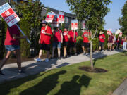Early morning light casts the shadow of picketers as union members and community members gather to strike outside Ridgefield High School after a deal has not been reached between the teachers union and school officials despite working without a contract since Sep. 1, as seen Friday morning, Sept. 9, 2022.