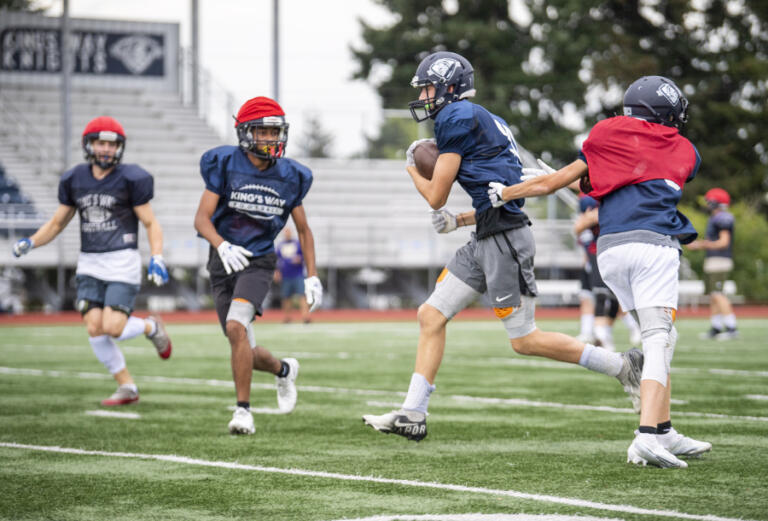 King's Way senior Alec Charlton, second from right, runs with the ball Tuesday, Sept. 13, 2022, during practice at King's Way Christian High School. The football team is 2-0 in its second year back competing at a varsity level.
