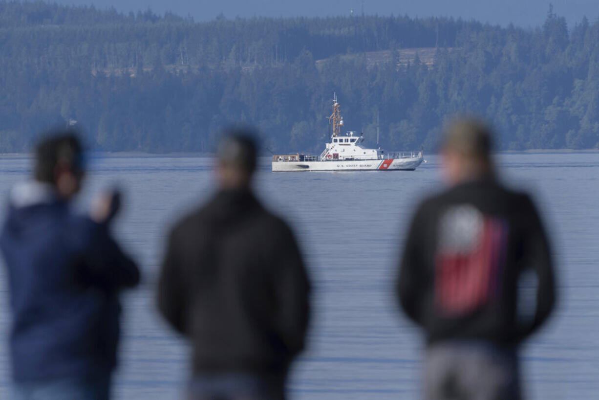 A U.S. Coast Guard vessel searches the area, Monday, Sept. 5, 2022, near Freeland, Wash., on Whidbey Island north of Seattle where a chartered floatplane crashed the day before. The plane was en route from Friday Harbor, Wash., to Renton, Wash.