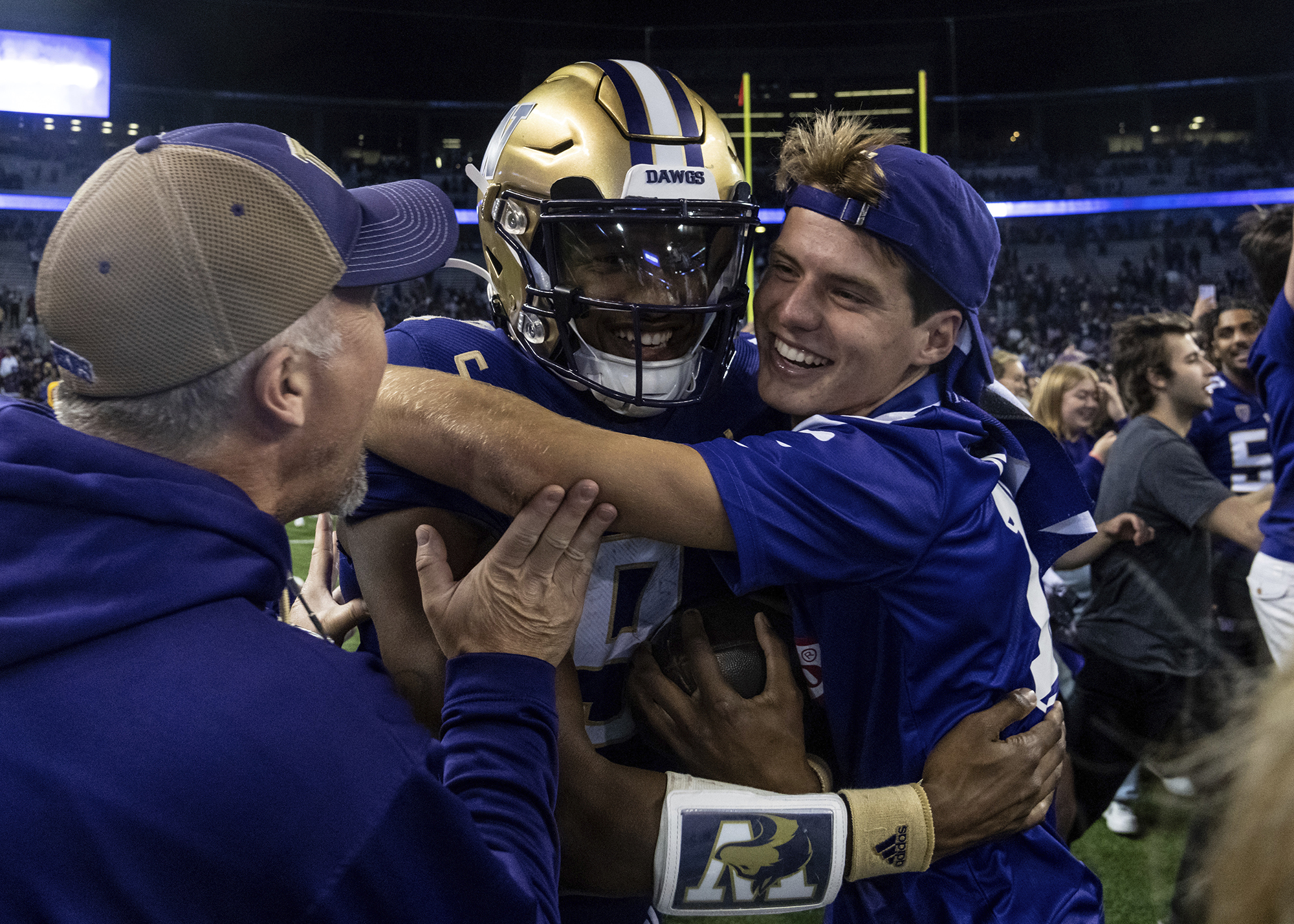 Fans celebrate with Washington quarterback Michael Penix Jr., center, after an NCAA college football game against Michigan State, Saturday, Sept. 17, 2022, in Seattle.