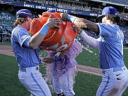 Kansas City Royals' Michael Massey is doused by Bobby Witt Jr., left, and MJ Melendez (1) after their baseball game against the Seattle Mariners Sunday, Sept. 25, 2022, in Kansas City, Mo. The Royals won 13-12.